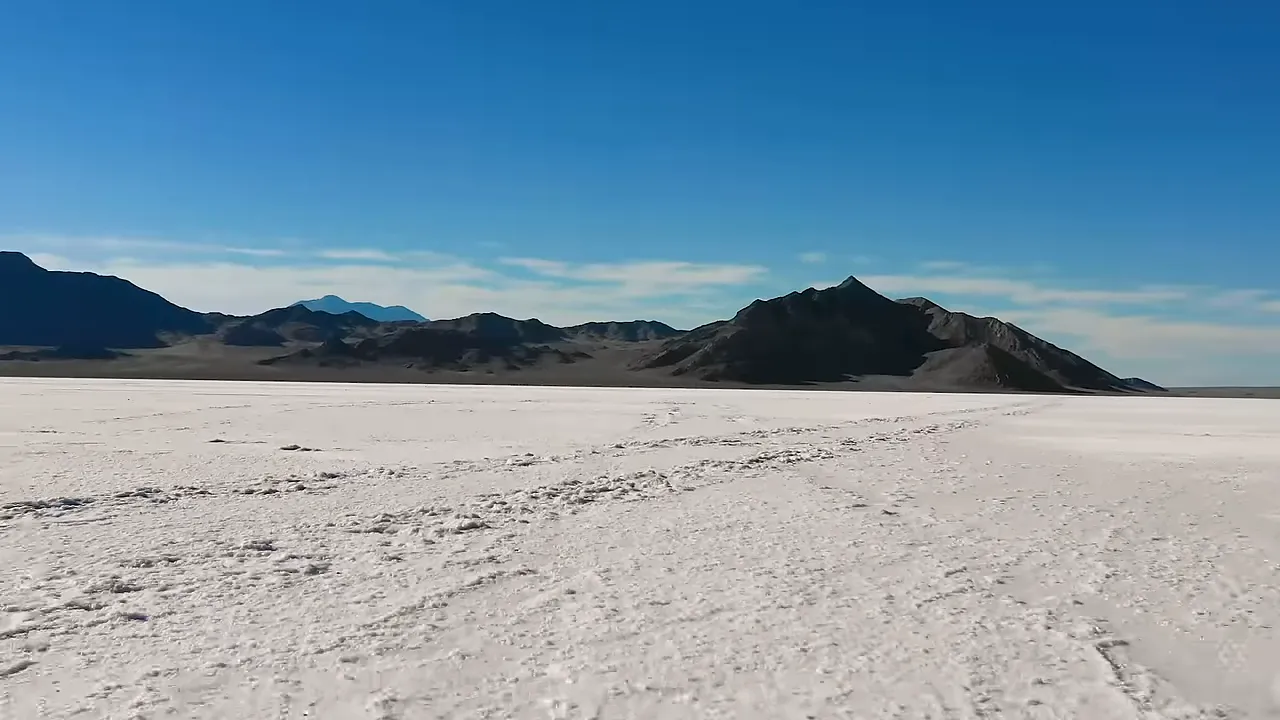 Wide white expanse of the Bonneville Salt Flats with mountain range in the background