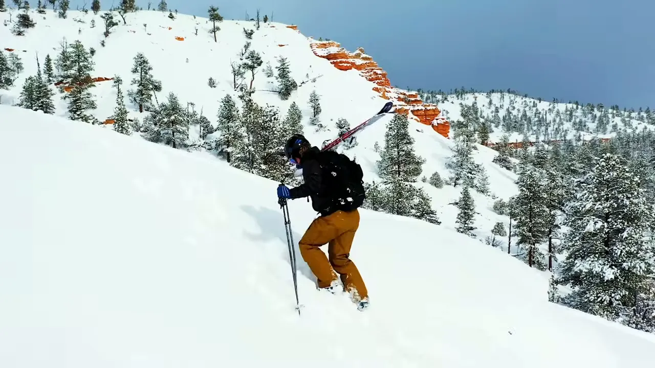 Backcountry winter activity near a canyon rim with hoodoo formations