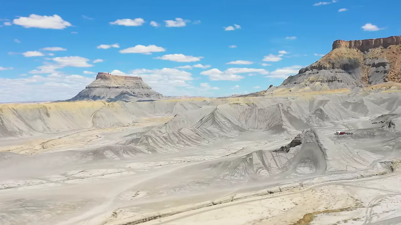 Reddish rock formations rising from an expansive desert-like landscape