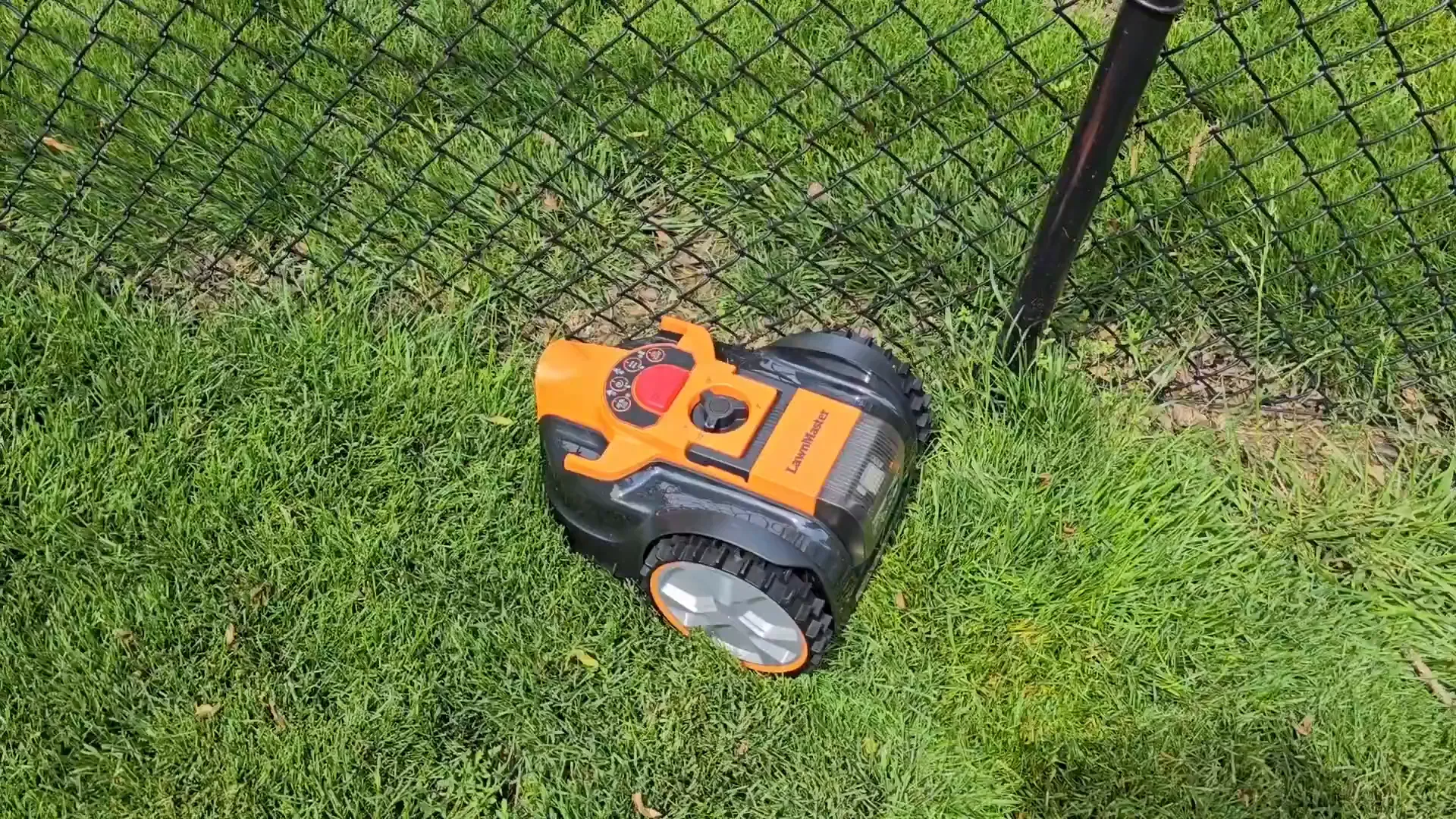 Underside of mower showing small spinning blades and drive wheels