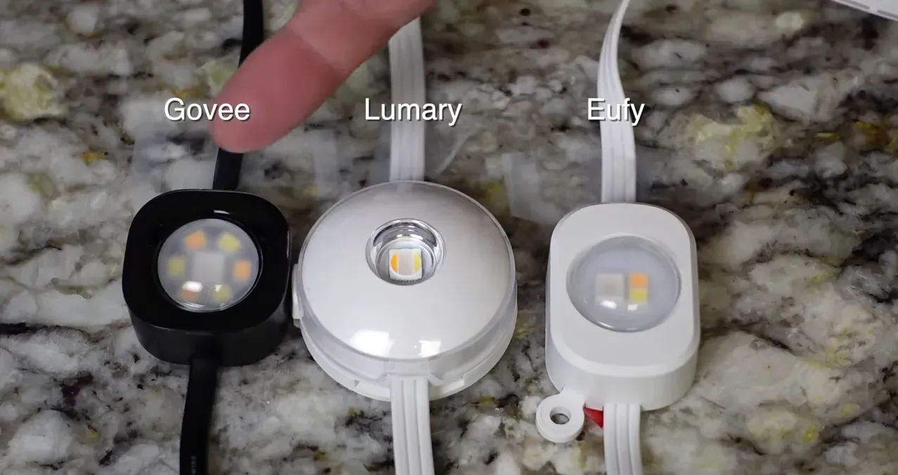 Close-up of three puck lights side-by-side, showing LED placement and lens differences