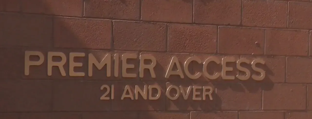 Bronze lettering on a brick wall reading 'PREMIER ACCESS 21 AND OVER' at Zion Canyon Hot Springs.