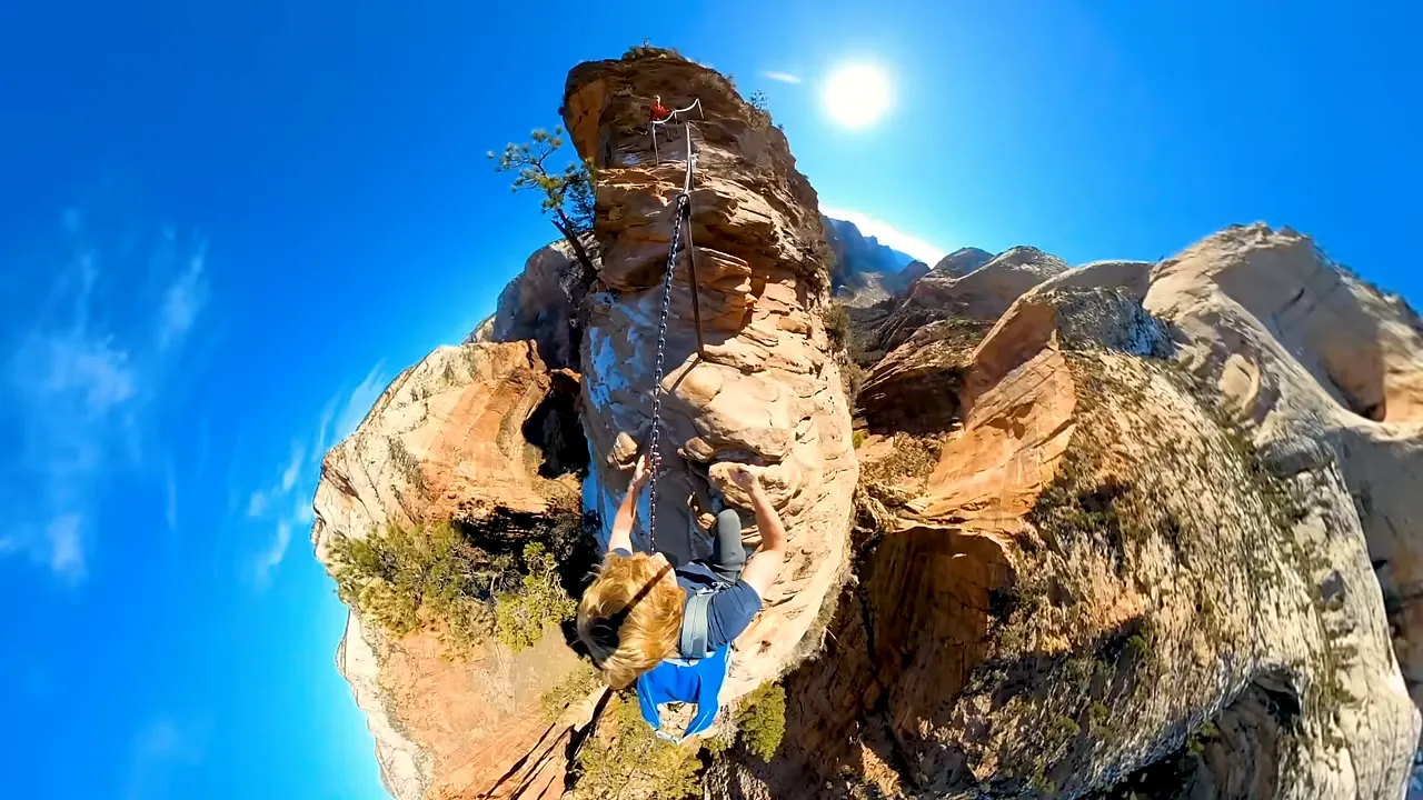A steep chain-assisted trail rising between towering red cliffs, illustrating the exposure hikers face on challenging canyon routes