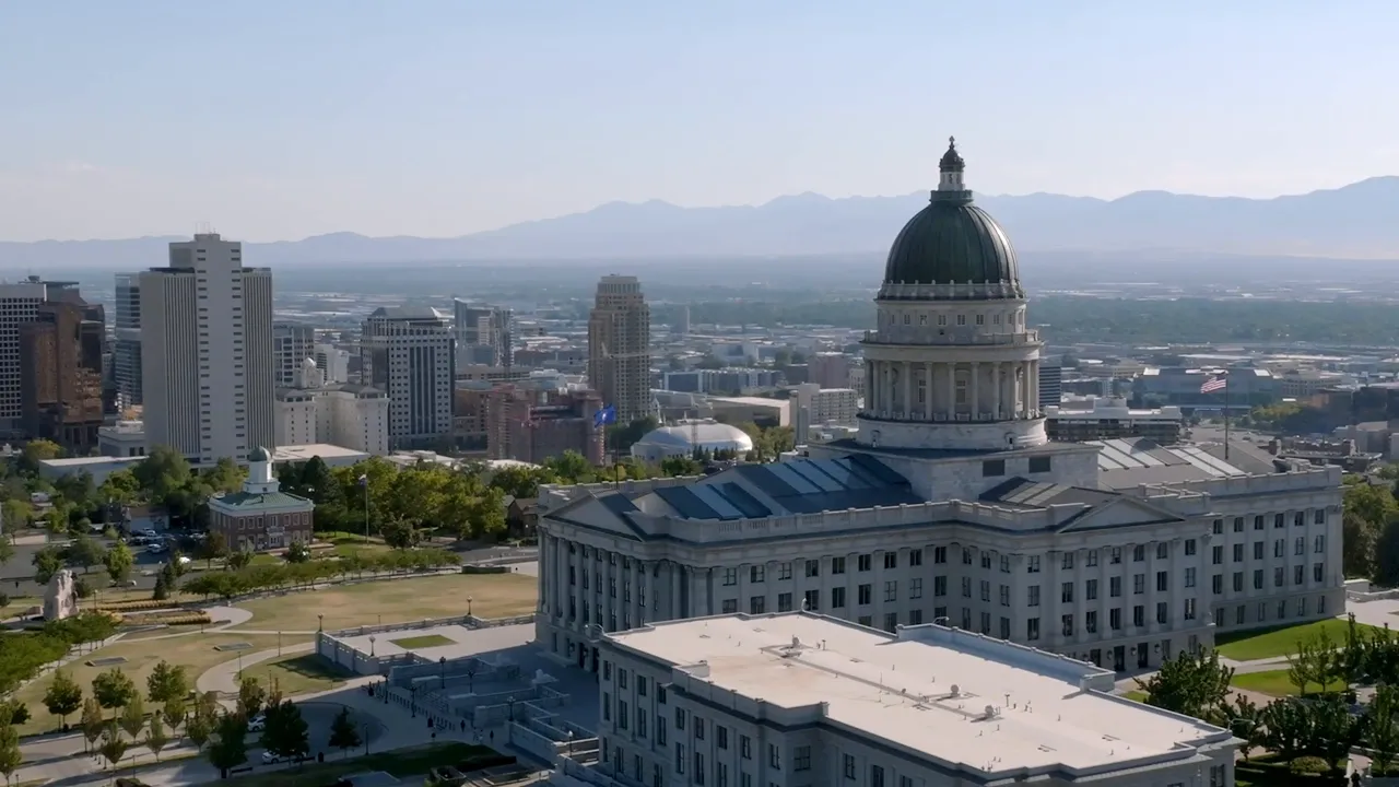 The Utah State Capitol building perched on Capitol Hill with the city and mountains in the background