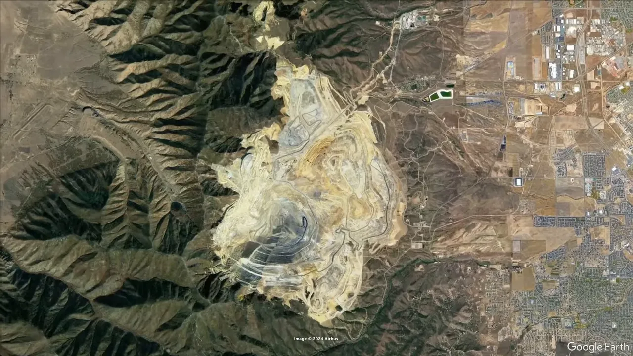 Vast open-pit copper mine viewed from an overlook with surrounding landscape
